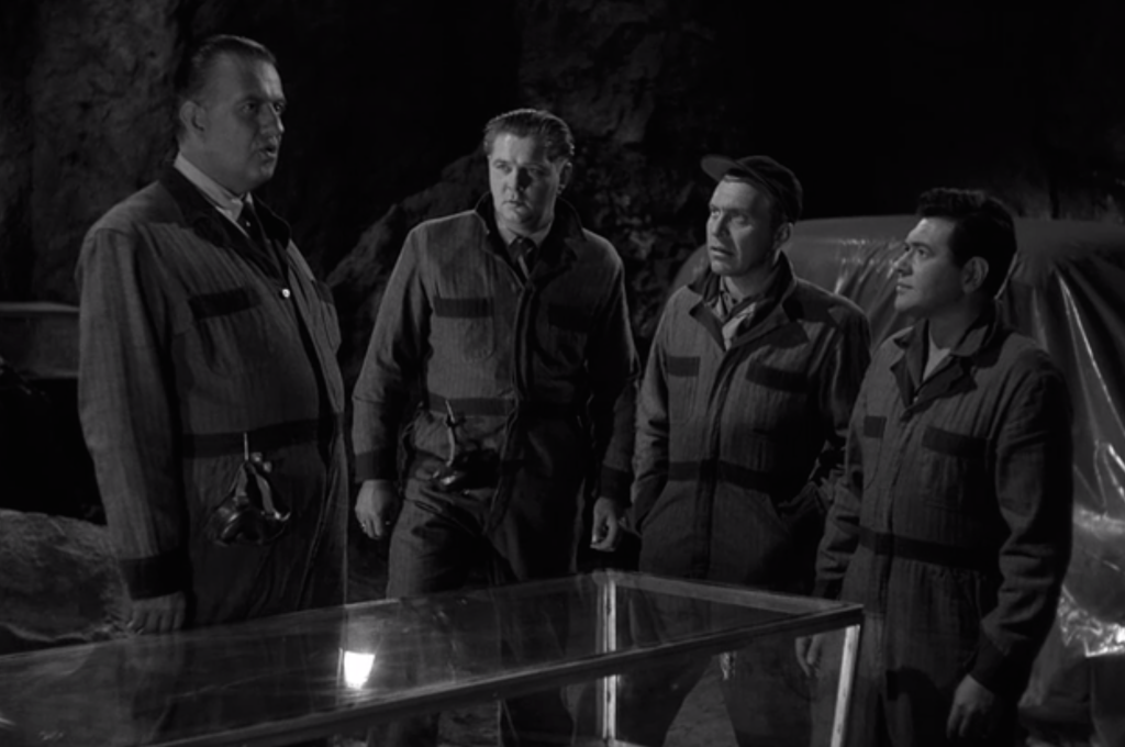 Four gold thieves ready themselves for a 100 year sleep in suspended animation.